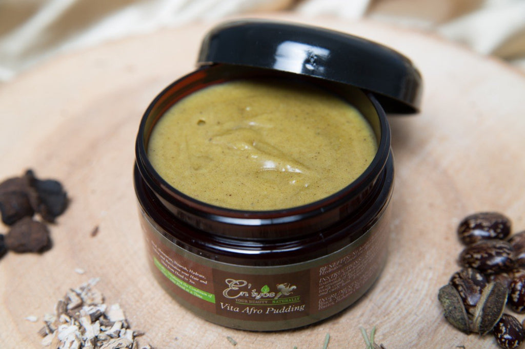 Vita(min) Afro Pudding handmade plant-based herb-infused medicinal luxury hair care - open jar image with herbs on wooden plank